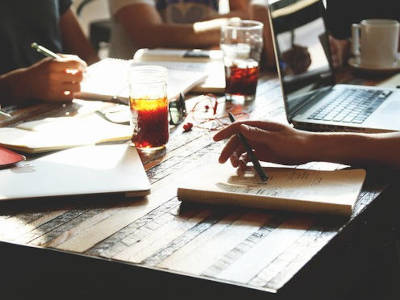 Tisch an dem mehrere Menschen arbeiten