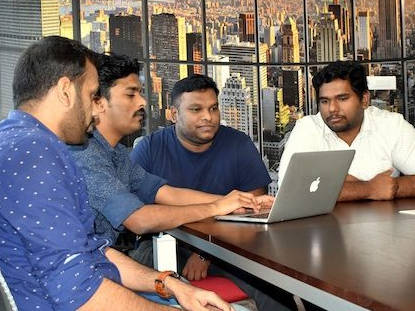 4 Männer arbeiten an einem Computer