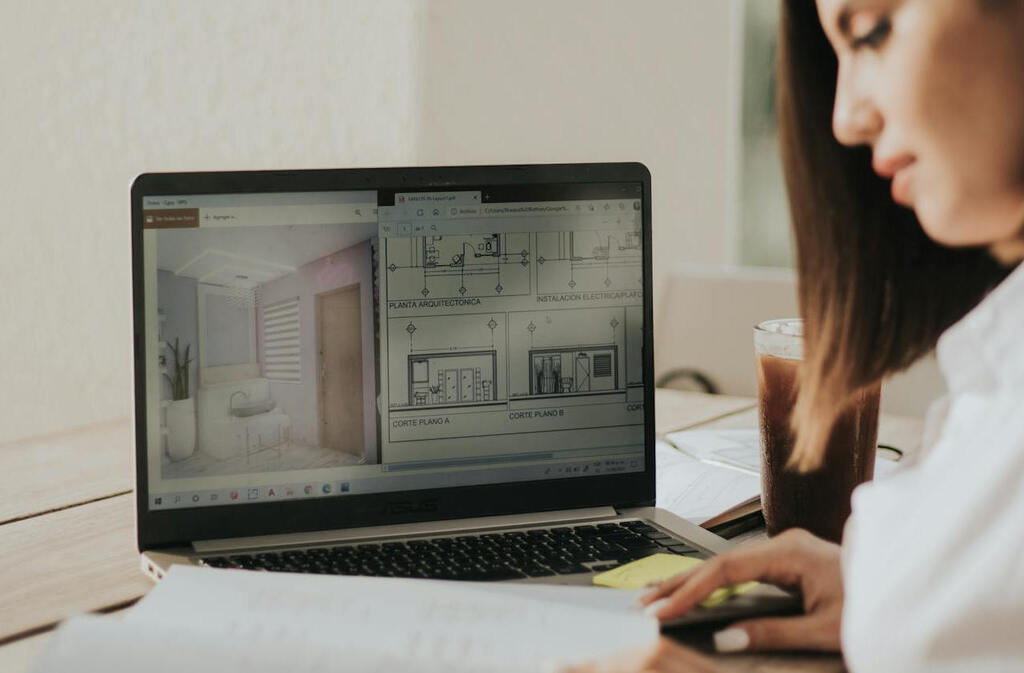 Frau vor einem Laptop mit Bauplänen